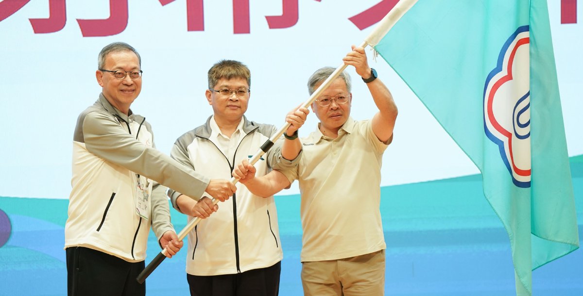 在教育部體育署副署長房瑞文（中）見證下，長榮大學將會旗交接給將再度承辦全大運的中央大學。攝/大專體總
